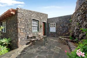 a stone house with a patio and a table and chairs at Las Adelfas Alta in Valverde