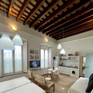 a living room with two beds and a table with chairs at Apartamentos turísticos CASA de los BALCONES in Chipiona