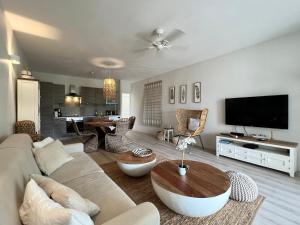 TV a/nebo společenská místnost v ubytování ET VOILA! Elegant one bedroom and beachfront apartment with pool!