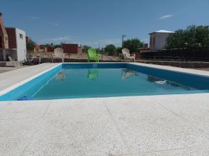 - une piscine d'eau bleue dans la cour dans l'établissement Cabañas Cafayate, à Cafayate