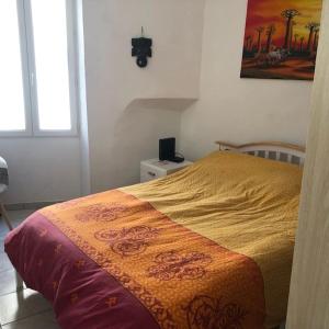 um quarto com uma cama com um cobertor amarelo em Coquette maison de village dans village typique, em Lapalme