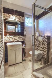 uma casa de banho com um chuveiro, um lavatório e um WC. em Apartmány PACIFIC em Demanovska Dolina