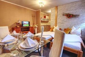 a room with two beds and a table with chairs at Apartmány PACIFIC in Belá