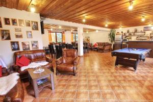 a living room with leather furniture and a pool table at Apartmány PACIFIC in Demanovska Dolina