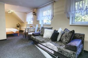 a living room with a couch and a table and windows at Apartmány PACIFIC in Demanovska Dolina