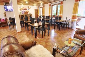 a living room with a couch and tables and chairs at Apartmány PACIFIC in Belá