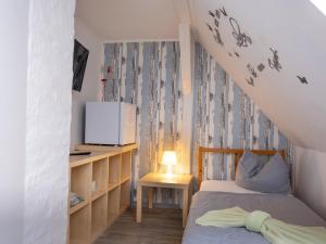 Habitación pequeña con 2 camas y TV. en Zimmervermietung K.Krause en Salzgitter