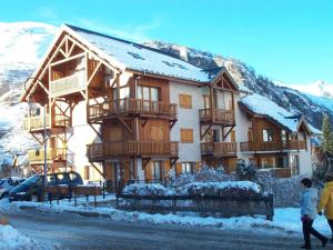 a large wooden building with snow on the mountains at Appartement Valloire, 3 pièces, 8 personnes - FR-1-263-455 in Valloire