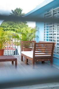 2 bancos de madera en un balcón con palmeras en La Esmeralda PR, en San Juan