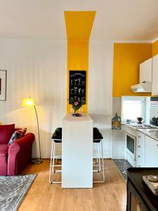 eine Küche mit einer weißen Insel im Wohnzimmer in der Unterkunft Light and Bright Central in Pristina