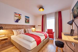 ガルミッシュ・パルテンキルヒェンにあるFelsenfestのベッドルーム1室(ベッド1台、赤い椅子付)