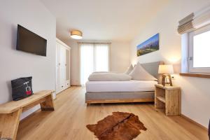 um quarto com uma cama e uma televisão na parede em BergJuwel em Garmisch-Partenkirchen