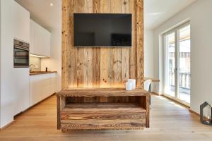 een keuken met een houten muur en een tv. bij Gams in Garmisch-Partenkirchen