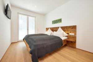 een slaapkamer met een groot bed en een televisie bij Gams in Garmisch-Partenkirchen