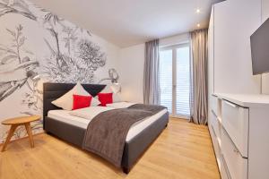 - une chambre avec un lit et des oreillers rouges dans l'établissement Huettenzauber, à Garmisch-Partenkirchen