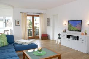 uma sala de estar com um sofá azul e uma televisão em Ferienwohnung Zugspitze em Garmisch-Partenkirchen