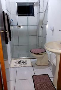 y baño con ducha, aseo y lavamanos. en Ap perto da praia, garagem privativa e wifi, en Florianópolis