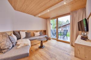 Haus Hoamat - Bergfeuer في فراشانت: غرفة معيشة مع أريكة وتلفزيون