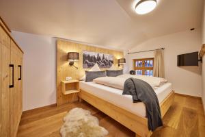 Haus Hoamat - Bergfeuer في فراشانت: غرفة نوم بسرير كبير وتلفزيون