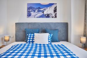 加爾米施－帕騰基興的住宿－BergZeit，一间卧室配有一张带蓝白色 ⁇ 面毯的床