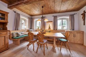 jadalnia z drewnianym stołem i krzesłami w obiekcie Haus Hoamat - Almrausch w mieście Farchant