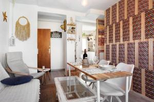 una sala de estar con mesa y sillas y una botella de vino en Casa Chipiron, en Vejer de la Frontera