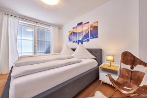1 dormitorio con 1 cama, 1 silla y 1 ventana en AlpenAmbiente, en Garmisch-Partenkirchen