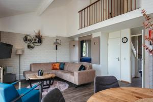ein Wohnzimmer mit Sofa und Tisch in der Unterkunft Veluwe Strandbad Elburg in Elburg
