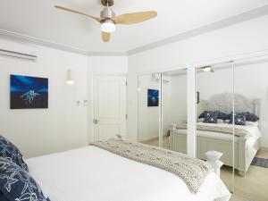 a white bedroom with a bed and a ceiling fan at Sago Garden Apartment at Royal Westmoreland in Saint James