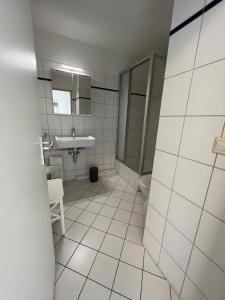 Baño blanco con lavabo y aseo en Appartementhaus Ostseeresidenz, en Heiligenhafen