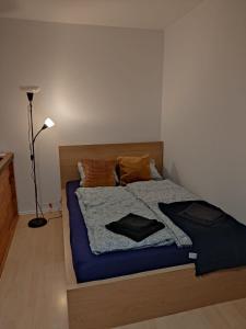 a bedroom with a bed with a blue blanket and a lamp at Gallery Apartament in Warsaw