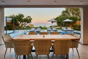 a dining room with a table and chairs and a pool at Villa Belen in Kipseli