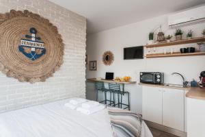 - une chambre avec un mur en briques blanches et un lit dans l'établissement Wake up with Acropolis view!, à Athènes