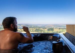 a man in a bath tub with a view at Mountain View in Llanfair Caereinion