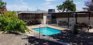 a fence around a swimming pool in a yard at Kelkiewyn Guesthouse Caledon in Caledon