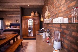 a kitchen with a counter and a brick wall at The Onion Cottage in Nieu-Bethesda