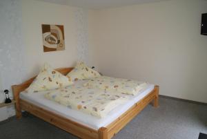 ein Schlafzimmer mit einem Holzbett mit Kissen in der Unterkunft Pension Sielmöwe in Neuharlingersiel