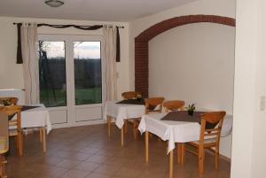 a dining room with two tables and a window at Pension Sielmöwe in Neuharlingersiel +20 photos