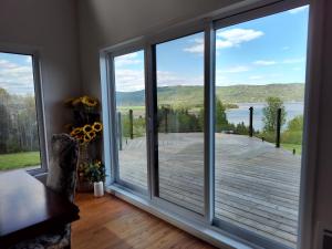 a room with a large window with a view of a deck at Auberge country inn in Baie-Saint-Paul