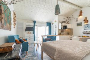 a bedroom with a bed and chairs and a kitchen at Libera Apartments in Stara Baška