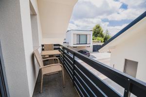 a balcony with two chairs and a view of a building at Mojčin Pisker Apartment House in Kranj