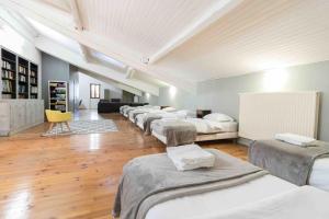 fila de camas en una habitación con suelo de madera en Domaine des Airs de Toscane, en Cazères
