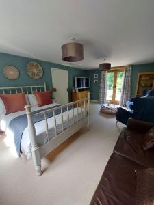 a bedroom with a bed and a living room at The Hen Den in Hopton Cangeford