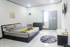 ein Schlafzimmer mit einem Bett, einer Tür und einem Teppich in der Unterkunft DD Grand Hotel in Ban Na Ta Kai