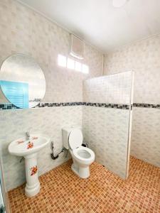 La salle de bains est pourvue de toilettes et d'un lavabo. dans l'établissement DD Grand Hotel, à Ban Na Ta Kai