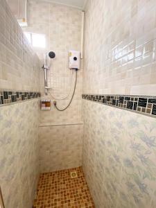 La salle de bains est pourvue d'une douche avec un pommeau de douche. dans l'établissement DD Grand Hotel, à Ban Na Ta Kai
