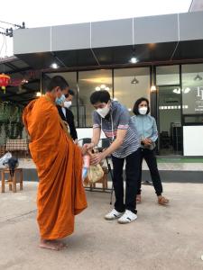 Un homme en robe tremblant la main avec un moine dans l'établissement DD Grand Hotel, à Ban Na Ta Kai