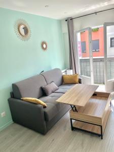 ein Wohnzimmer mit einem Sofa und einem Tisch in der Unterkunft Chic And Cosy Studio proche ParisAéroport CDG in Villepinte