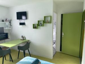 a room with a table and chairs and a green door at Résidence La Cigale du Désire Séjour chez l habitant in Riez