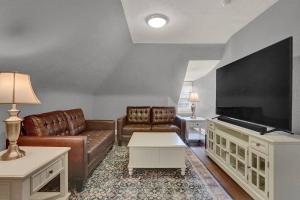 a living room with a couch and a flat screen tv at Suites on Seneca - Gorgeous One Bedroom Apartment in Harrisburg